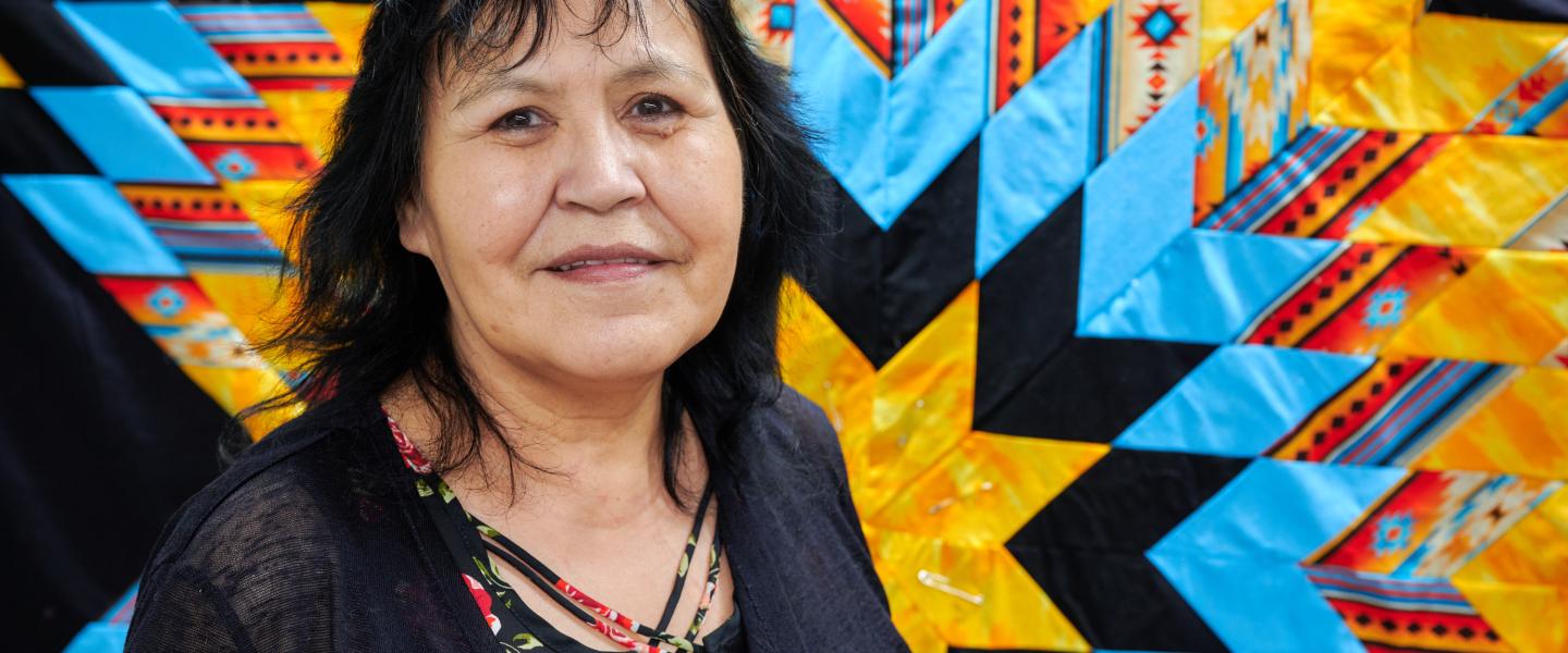 Elder Nina in front of a star blanket